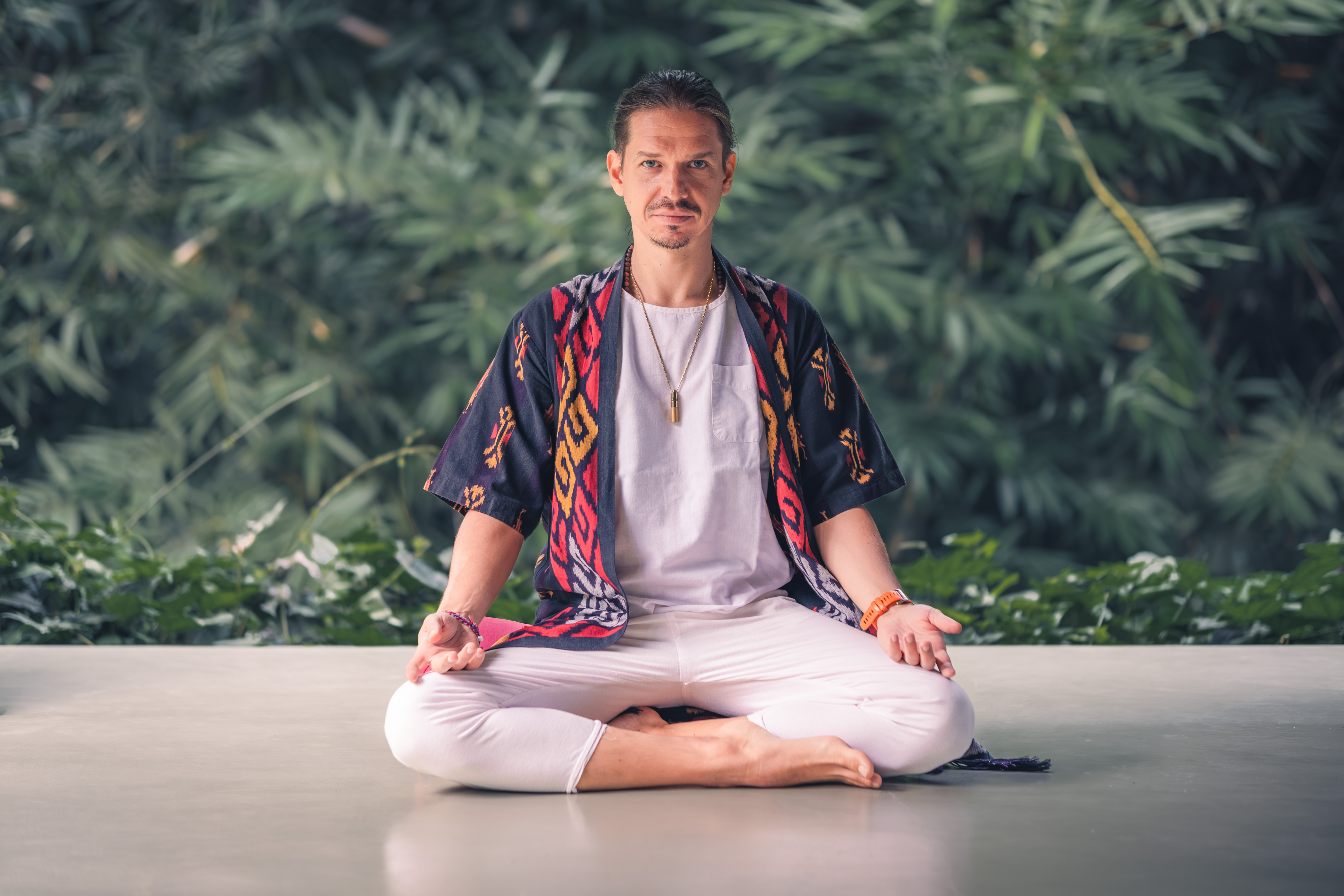 Ritam, tantric teacher, seated in meditation in a lush jungle shala